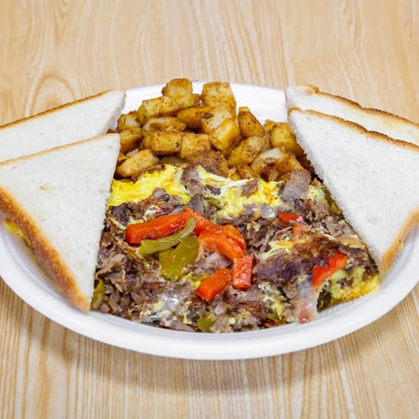 Hearty breakfast plate with scrambled eggs, steak, peppers, home fries, and white toast.